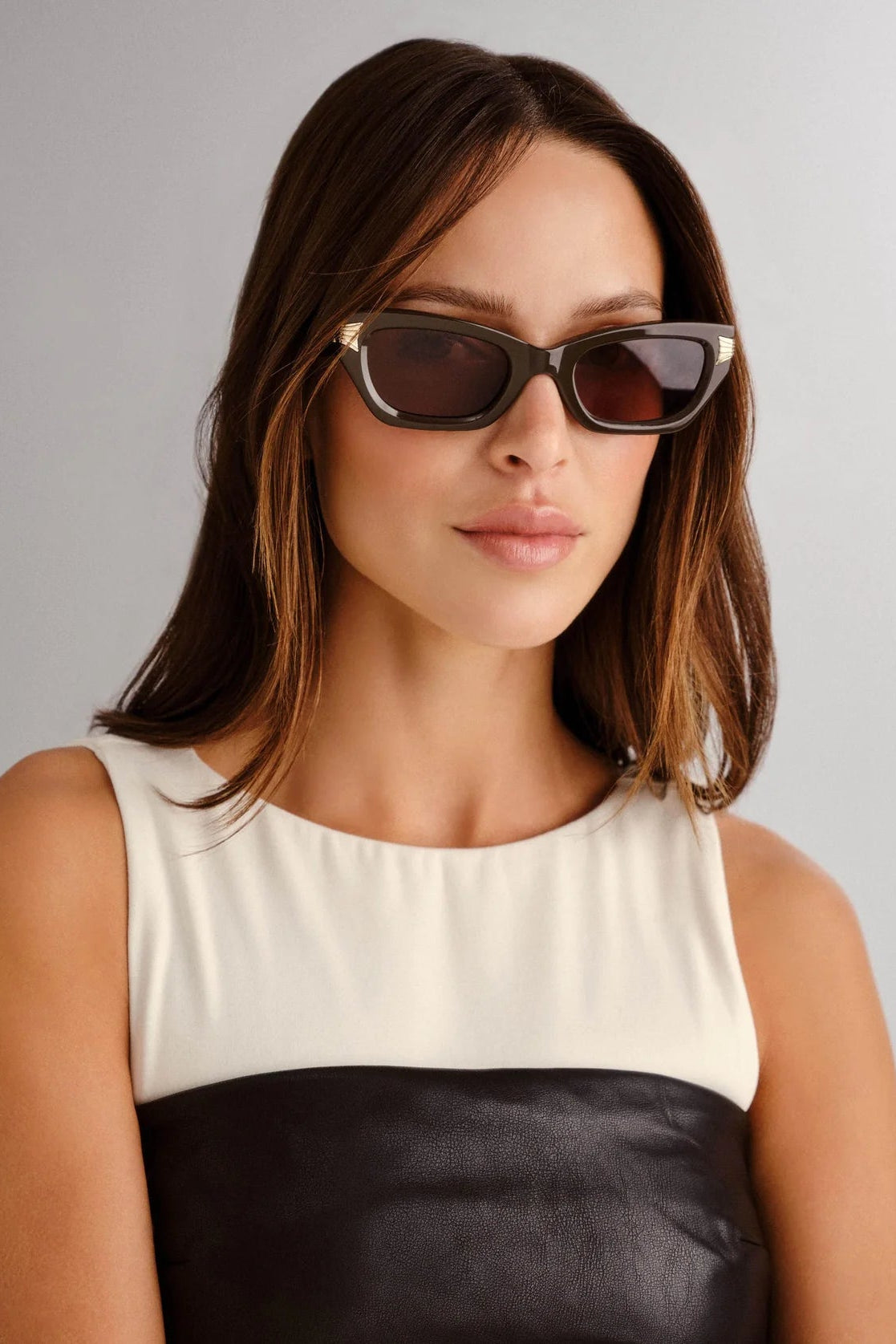 Woman wearing sunglasses with a plain background