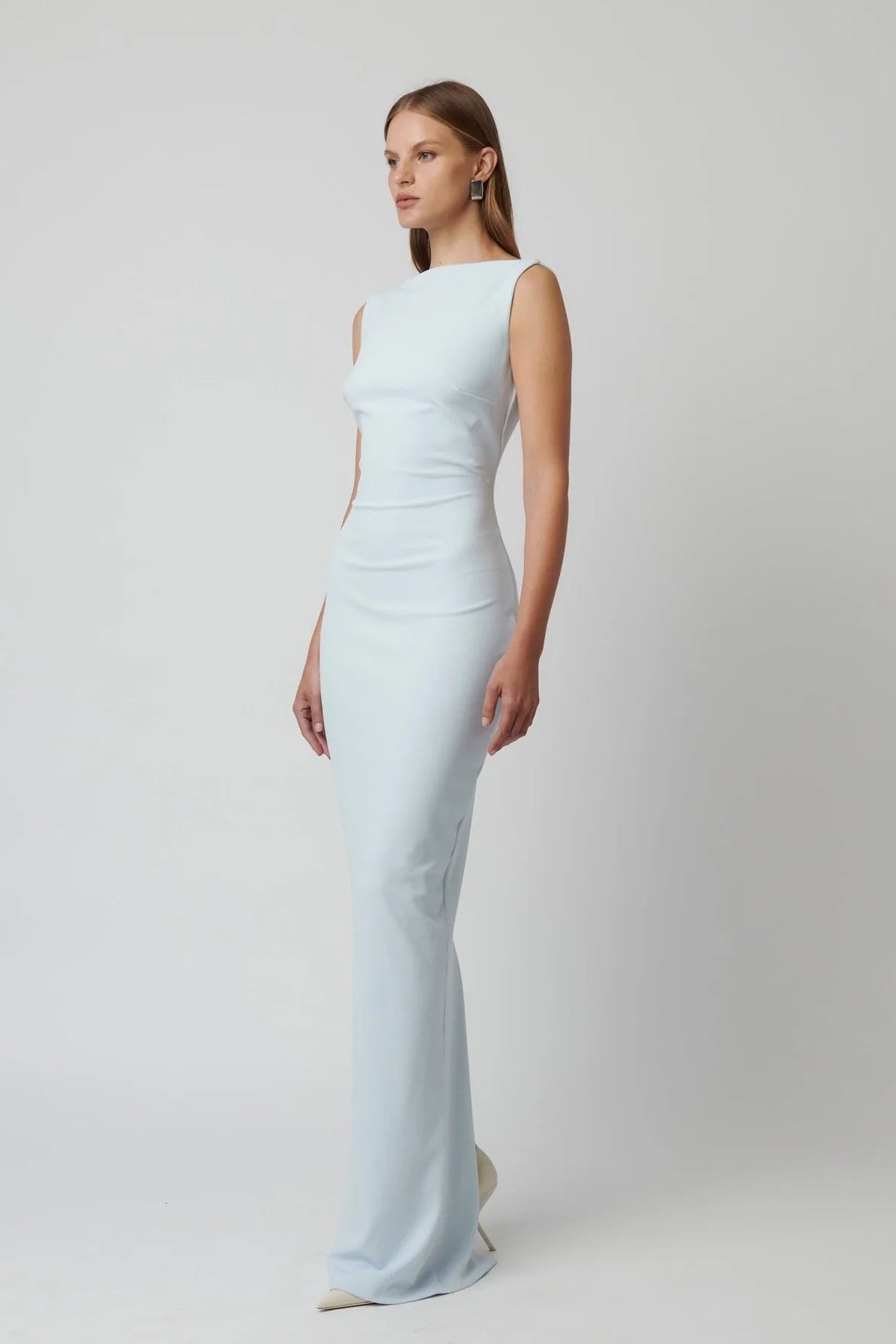 Woman wearing a light blue evening gown against a white background